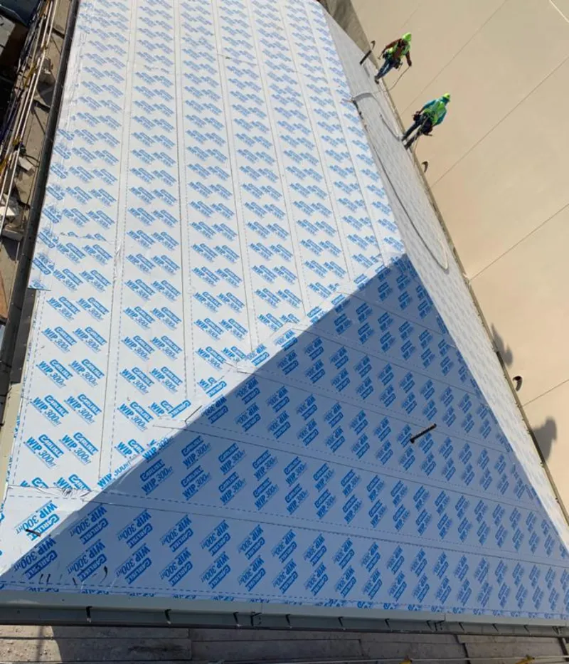 Professional roofers installing underlayment on a metal roof in Ripon